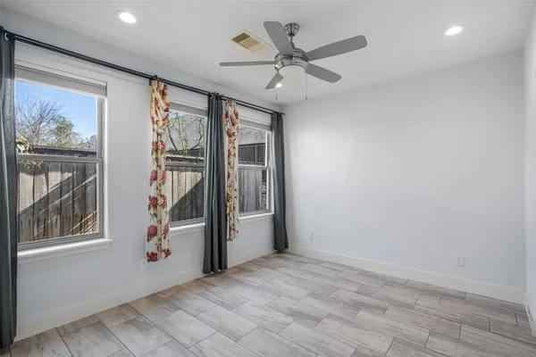 an empty room with windows and fan