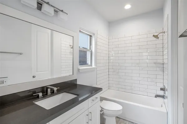 a bathroom with a sink a toilet a mirror and shower