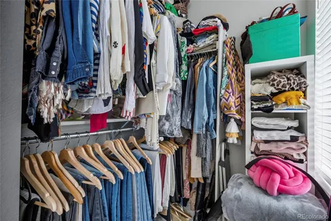 a view of walk in closet with clothes and shoes