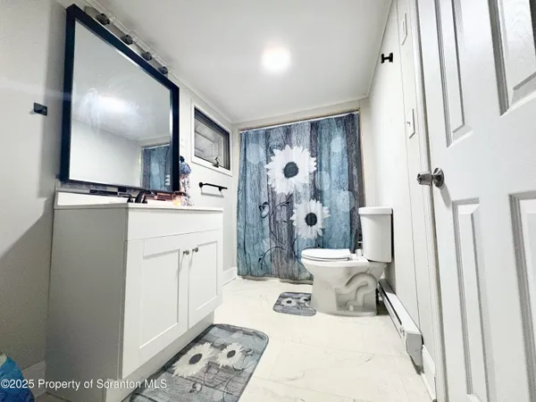 a living room with furniture a flat screen tv and a white refrigerator