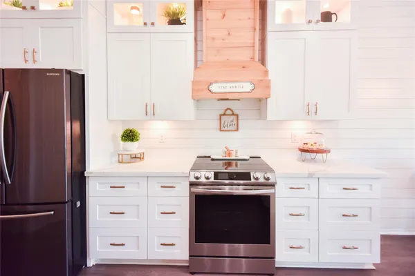 a kitchen with stainless steel appliances a stove a refrigerator and cabinets