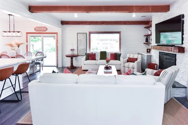 a living room with furniture a flat screen tv and a fireplace