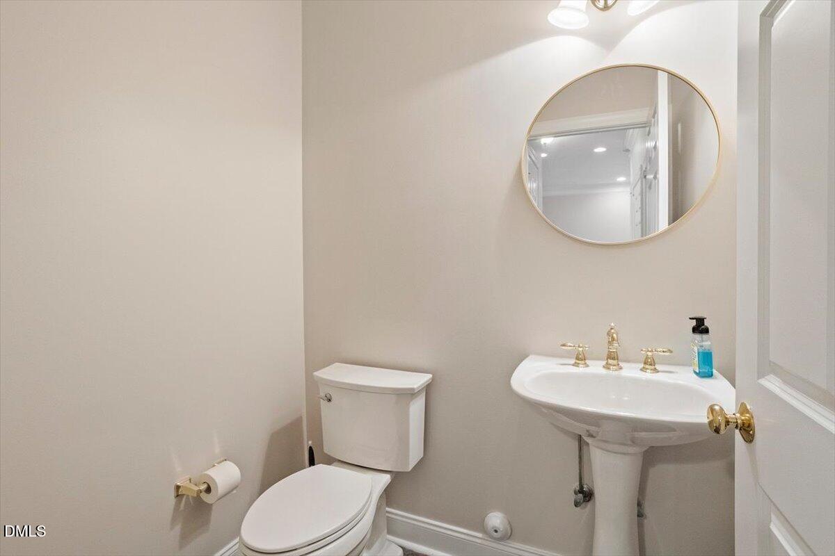 11213 Maplecroft Court Raleigh, NC 27617 - Photo 16 of 44 a bathroom with a toilet a sink and mirror