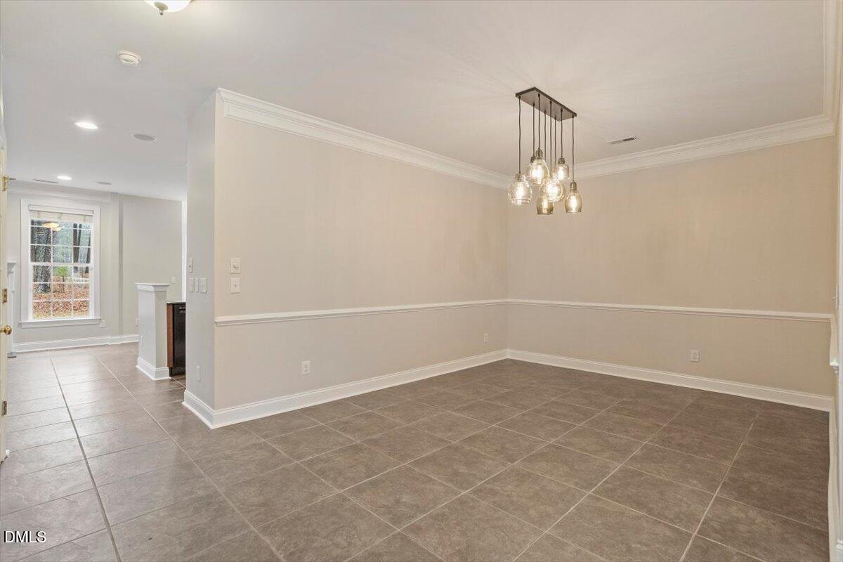 11213 Maplecroft Court Raleigh, NC 27617 - Photo 17 of 44 an empty room with chandelier and windows