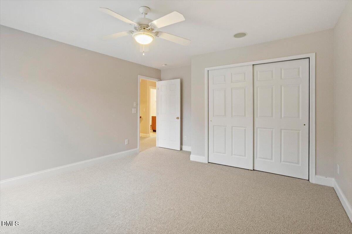11213 Maplecroft Court Raleigh, NC 27617 - Photo 22 of 44 an empty room with a ceiling fan and a window