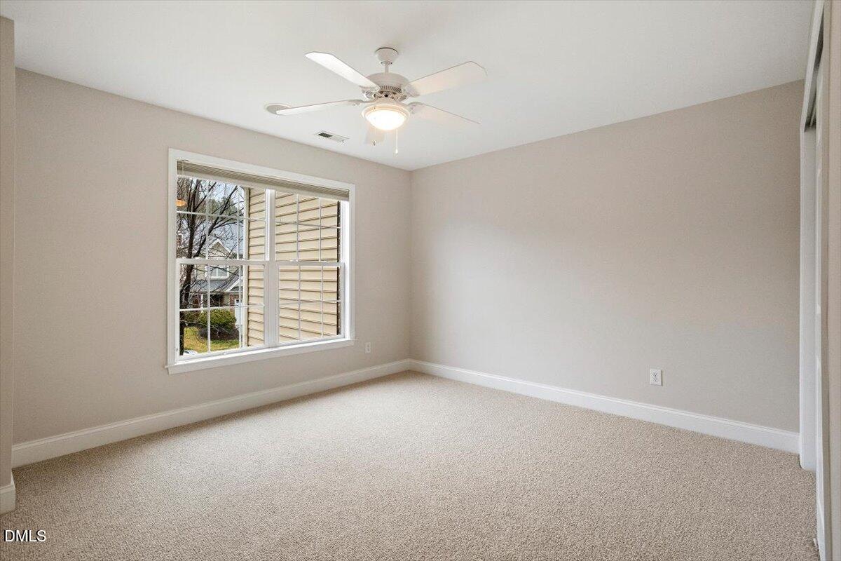 11213 Maplecroft Court Raleigh, NC 27617 - Photo 23 of 44 an empty room with windows and chandelier fan