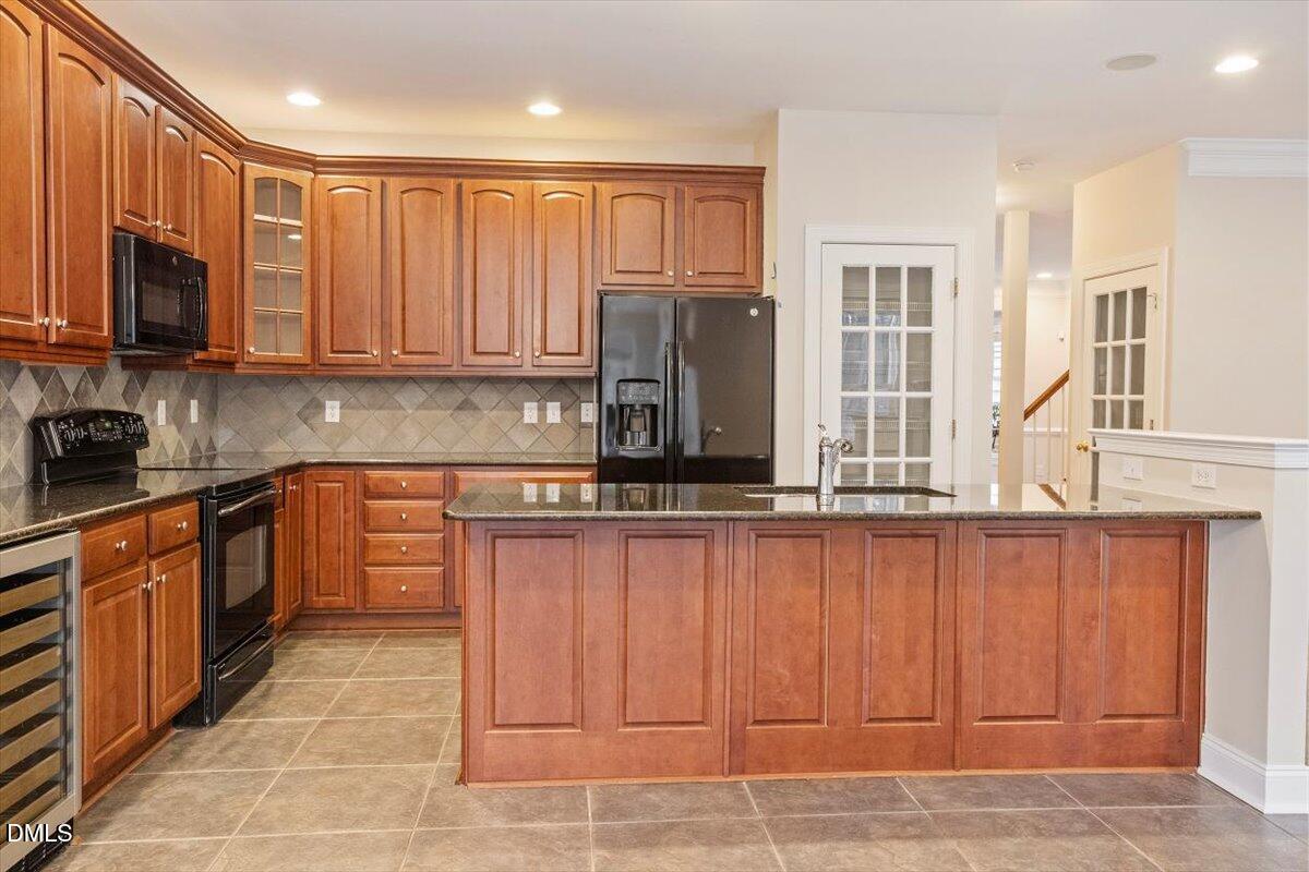 11213 Maplecroft Court Raleigh, NC 27617 - Photo 3 of 44 a kitchen with stainless steel appliances granite countertop a stove a sink and a microwave