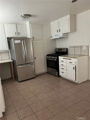 a kitchen with stainless steel appliances granite countertop a refrigerator sink and stove