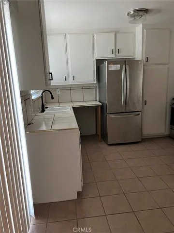 a kitchen with a sink a refrigerator and cabinets