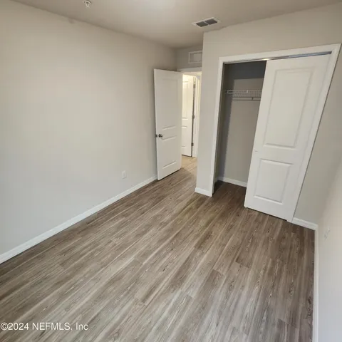 an empty room with wooden floor and closet