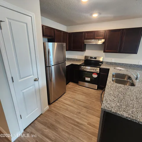 a kitchen with granite countertop stainless steel appliances and wooden cabinets