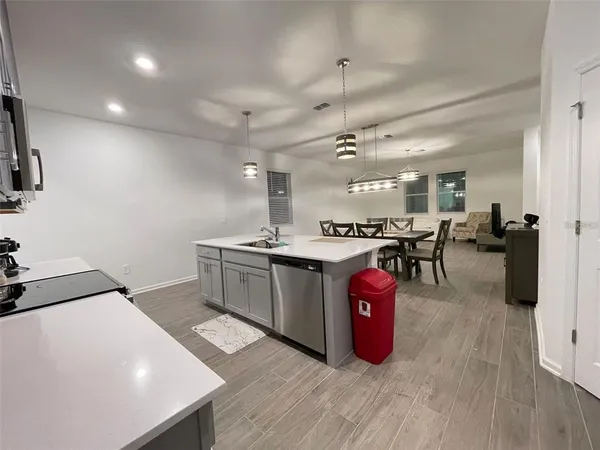 a kitchen with stainless steel appliances a sink a stove top oven a counter space and cabinets