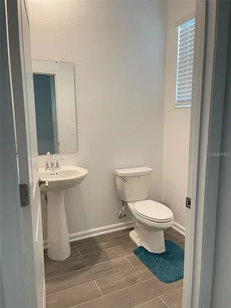 a bathroom with a toilet and a mirror