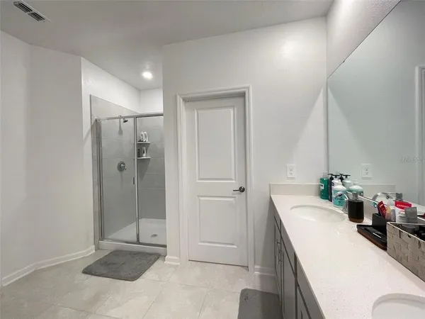 a bathroom with a tub shower sink and mirror
