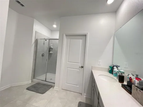 a bathroom with a shower a sink and mirror