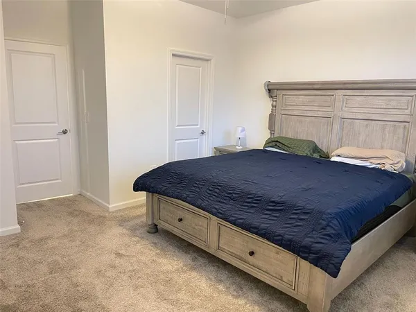a spacious bedroom with a bed and a chandelier