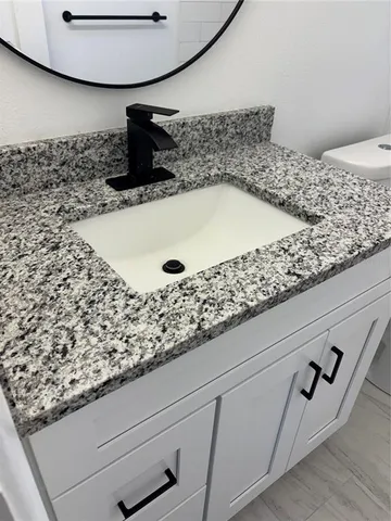 a bathroom with a granite countertop sink
