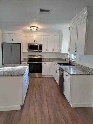 a kitchen with granite countertop a sink and steel appliances