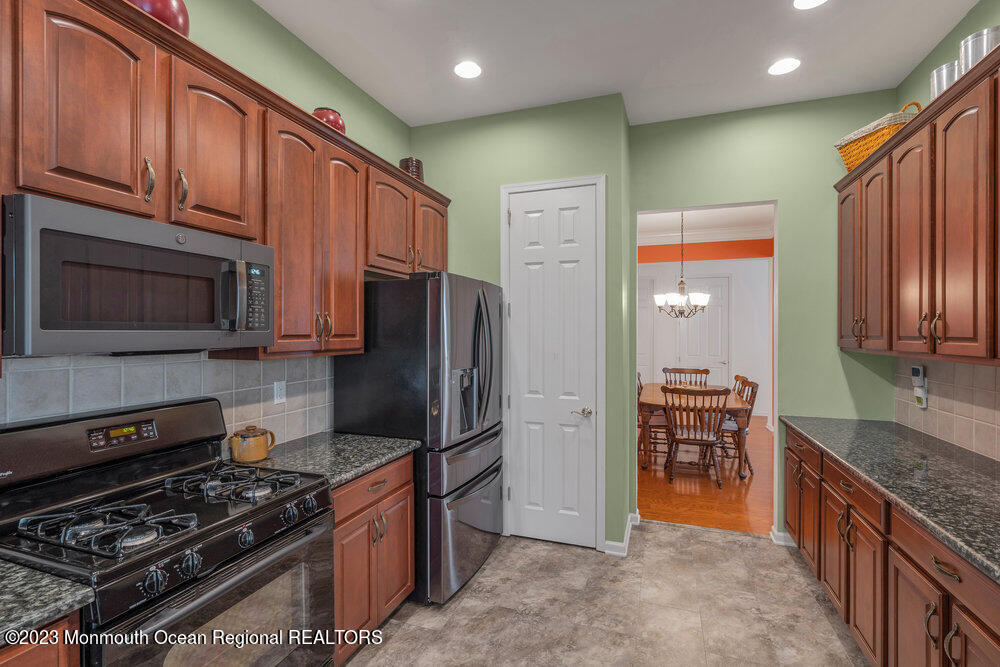 10 Crooked Stick Road Jackson, NJ 08527 - Photo 13 of 52 a kitchen with stainless steel appliances granite countertop a stove refrigerator and microwave