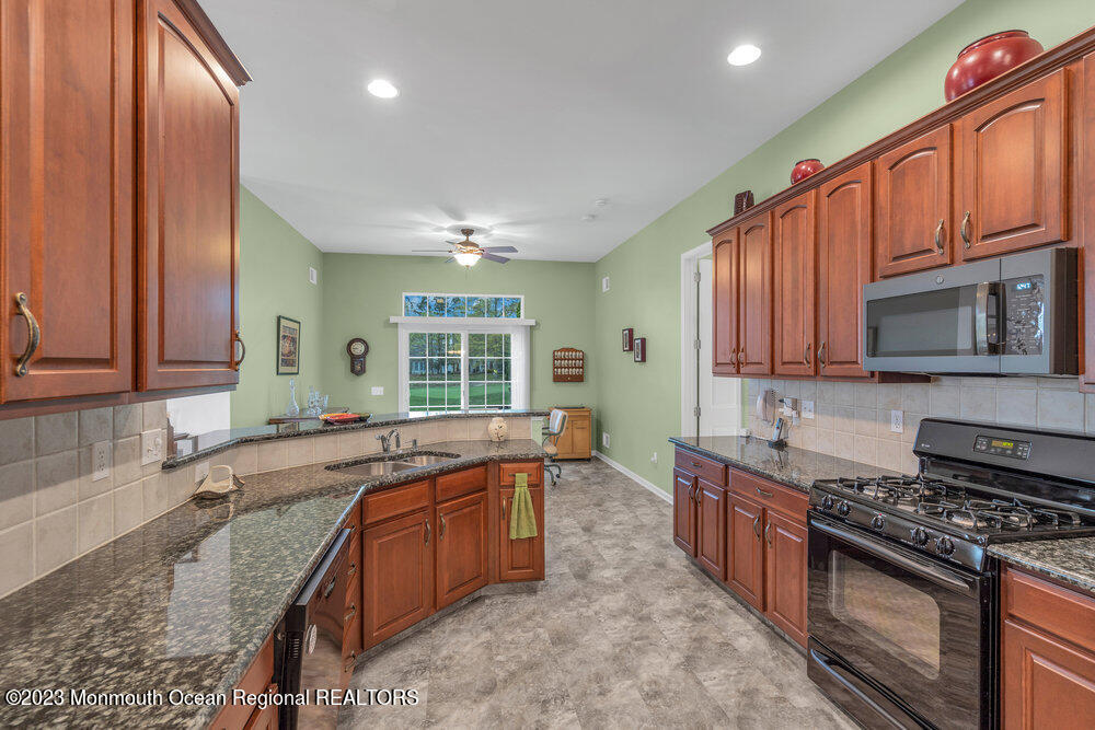 10 Crooked Stick Road Jackson, NJ 08527 - Photo 15 of 52 a large kitchen with stainless steel appliances granite countertop a stove a sink and a microwave