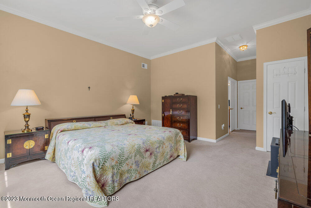 10 Crooked Stick Road Jackson, NJ 08527 - Photo 26 of 52 a bedroom with a bed and a chandelier