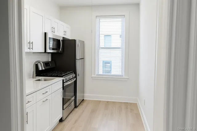 a kitchen with white cabinets and black appliances