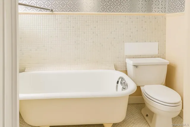 a white toilet sitting next to a white sink and vanity