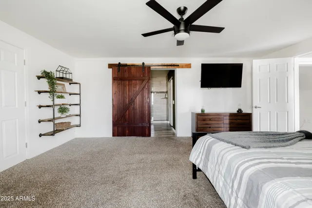 a spacious bedroom with a bed and a television