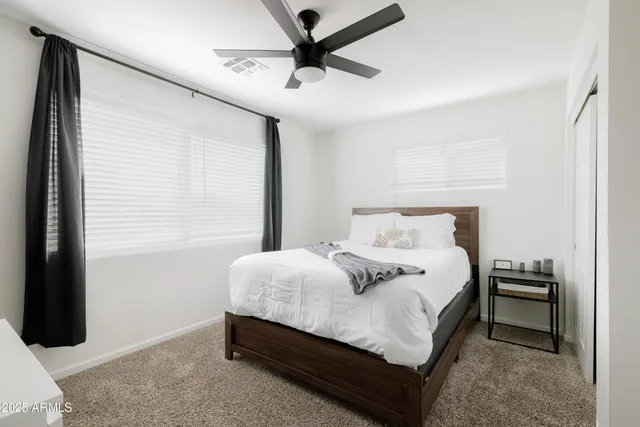 a bedroom with a bed and a ceiling fan
