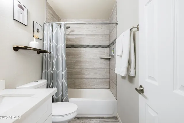 a bathroom with a shower a toilet and a tub