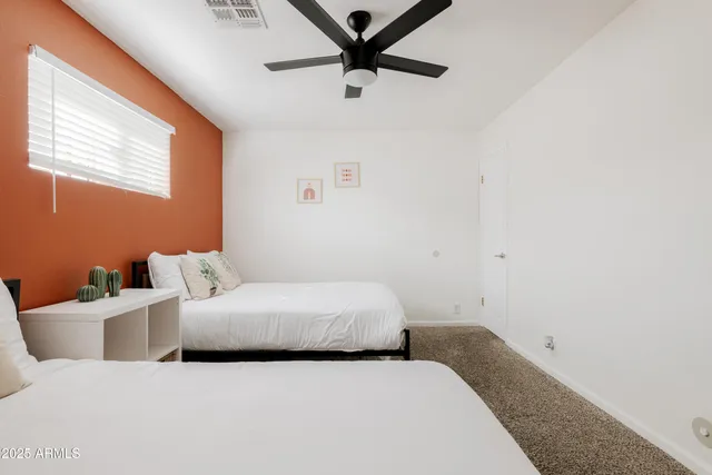 a bedroom with a bed and a ceiling fan