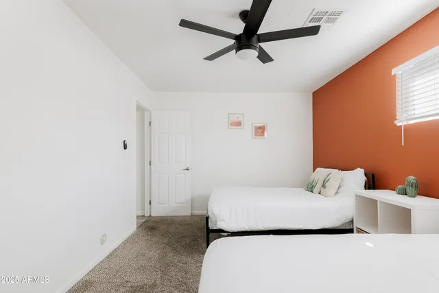 a bedroom with a bed and a ceiling fan
