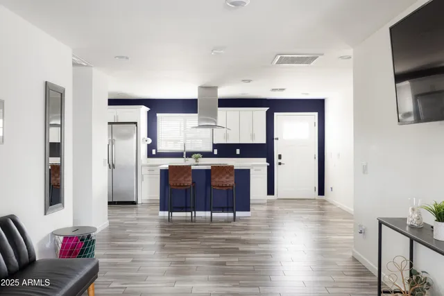 a living room with stainless steel appliances kitchen island granite countertop furniture and a fireplace