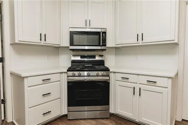 a kitchen with white cabinets and appliances