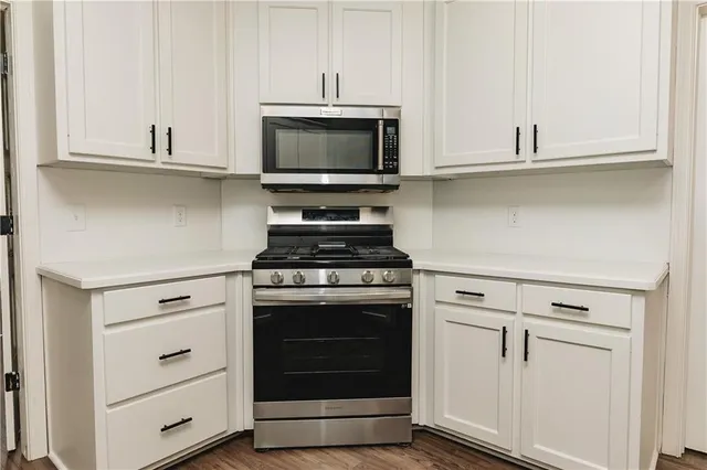 a kitchen with white cabinets and appliances