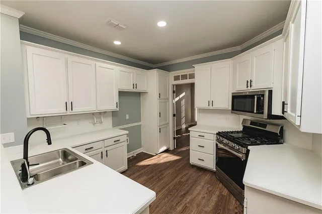 a kitchen with stainless steel appliances a stove a sink a refrigerator and cabinets