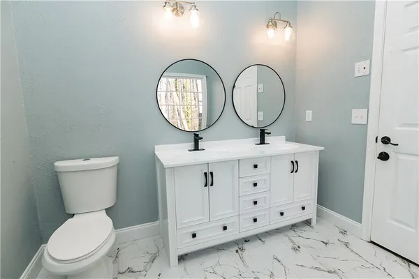 a bathroom with a toilet a sink and a mirror