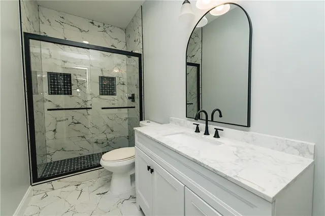 a bathroom with a sink a toilet and shower