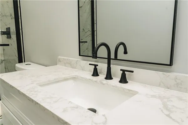 a bathroom with a sink and a bed