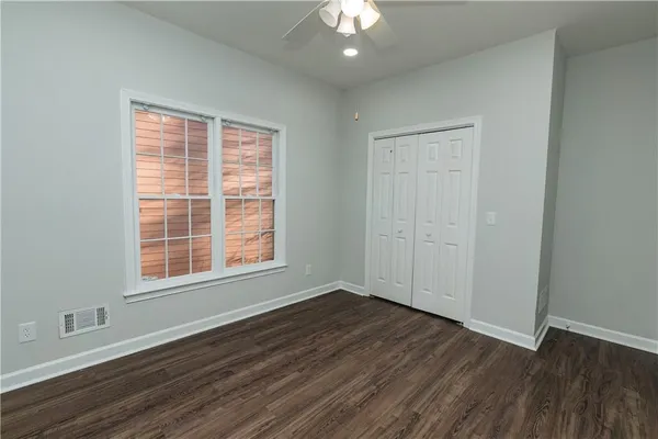 an empty room with wooden floor and windows