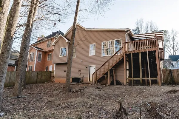 a view of a house with a yard and large tree