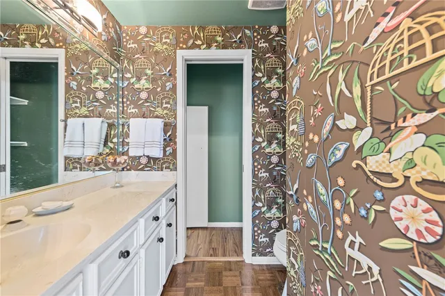 a bathroom with a sink and mirror with bathtub