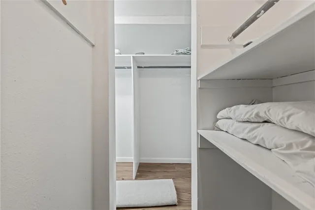 a view of walk in closet with clothes