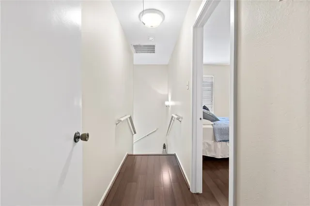 a view of a hallway with wooden floor and staircase