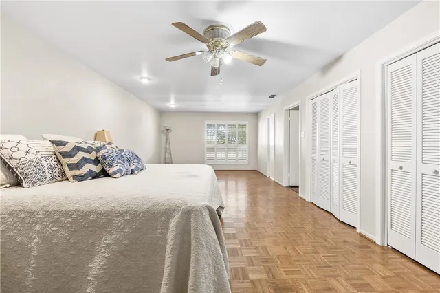 a spacious bedroom with a large bed and a chandelier