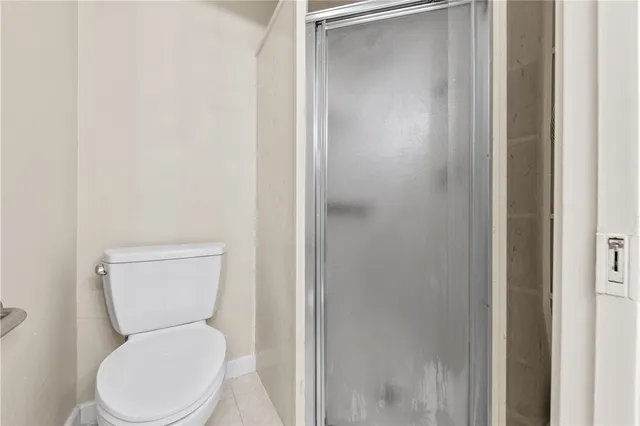a white toilet sitting next to a shower