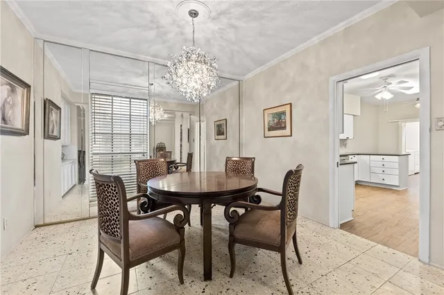 a view of a dining room with furniture a chandelier and wooden floor