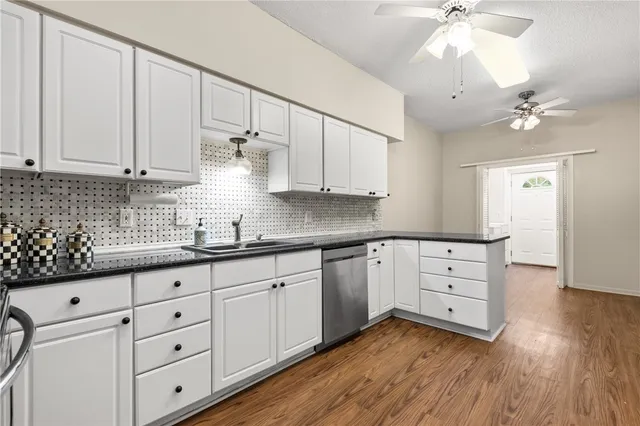 a kitchen with granite countertop white cabinets and white appliances