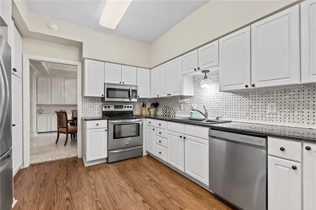 a kitchen with granite countertop white cabinets and white appliances