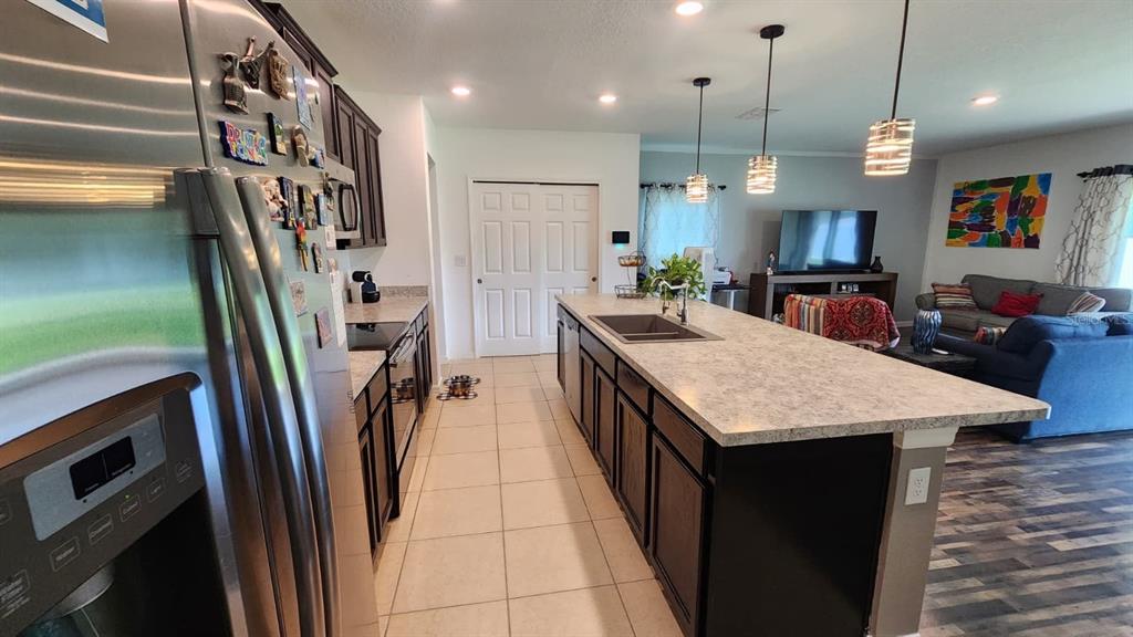 4540 Lake Russell Road Kissimmee, FL 34746 - Photo 24 of 35 a open kitchen with stainless steel appliances granite countertop a granite counter top a sink dishwasher and a refrigerator